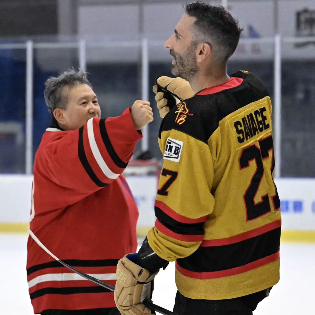 Two players sharing a lighthearted moment on the ice